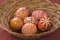 Red and orange painted Easter eggs in brown wicker basket, traditional Easter still life