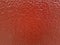 Red orange painted textured wall, natural light closeup