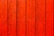 Red orange painted wooden wall plank weathered wood surface texture background.