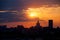 Red and orange sky with clouds and silhouette of cranes, construction and a skyscraper. Moscow