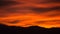 Red and Orange Sunset with Mountain Silhouette and Clouds