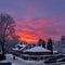 Red orange winter sky - sunset in the small snowy town