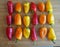 Red Orange and Yellow Peppers In Rows on Cutting Board