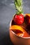 Red oranges and strawberry cocktail in copper mug variation of Moscow mule on the wooden background