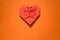 red origami paper heart on orange background, valentines day greeting card