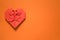 Red origami paper heart on orange background, valentines day greeting card