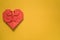 Red origami paper heart on yellow background, valentines day greeting card