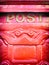 Red ornate mailbox detail with the word post on it