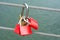 Red padlocks hanging on a steel cable