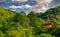 Red pagoda on a green hill surrounded by trees in Kiyomizudera temple