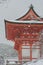 Red Pagoda at Kiyomizu-dera temple with tree covered white snow background.