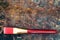 Red paintbrush on rusty ground, top view