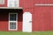 Red painted barn with white door and window trim