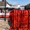 Red Painted Metal Crowd Safety Control Barriers Stacked On The Roadside