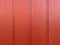 Red painted wall fence wood boards siding fresh paint maroon stain cabin house