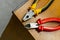 Red pair of wire cutters, a wiring repair tool lies on the edge of the master table