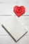 Red paper folded origami heart on white painted wooden rustic table, top view. Valentines day love symbol decoration. Nice