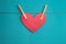 Red paper heart attached to a rope with wooden pins