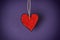 Red paper heart shape against purple background