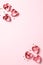 Red paper hearts and confetti on pink vertical background
