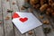 Red paper hearts, envelope and dry flowers on wooden table, toned vintage still life