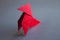 Red paper hen origami isolated on a grey background