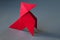 Red paper hen origami isolated on a grey background