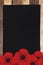 Red paper poppy flower and black paper on old wooden table background