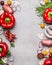 Red paprika and diverse vegetables and cooking ingredients on gray stone background, top view, frame, vertical