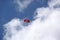 Red parachute wing in a blue sky with white clouds