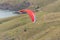 Red paraglider in flyght over slopes at Taylors Mistake bay  ocean shore, Christchurch, New Zealand