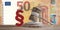 Red paragraph and judge gavel in front of a fifty Euro banknotes 3d-illustration