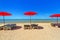 Red parasol with deckchair on tropical beach