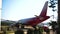 Red passenger airliner parked during service at the international terminal of the city of Tivat.