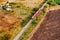 Red passenger train traveling through countryside, aerial view