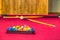 Red pastel pool table with balls in a rack