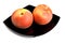 Red peaches on black dish