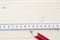 Red pencil and folding ruler lying on wooden board