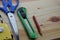 A Red Pencil, Paper Knife, Scissor and A Measuring Tape With Wooden Background