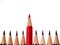 Red pencil standing out from crowd of plenty identical black fellows on white background. business success concept