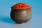 Red pepper powder in a beautiful bowl, blue background