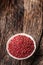 Red peppercorn in bowl on oak table