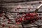 Red peppercorn in bowl and spoon on oak table