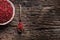 Red peppercorn in bowl and spoon on oak table