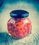 Red peppers drops in glass jar