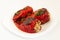 Red peppers stuffed with meat and rice. Filled peppers in white plate