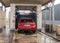 Red Peugeot 208 model car in a car wash tunnel