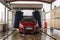 Red Peugeot 208 model car in a car wash tunnel