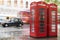 Red Phone cabines in London and vintage taxi.Rainy day.