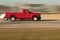 A red pickup truck speeds down the expressway